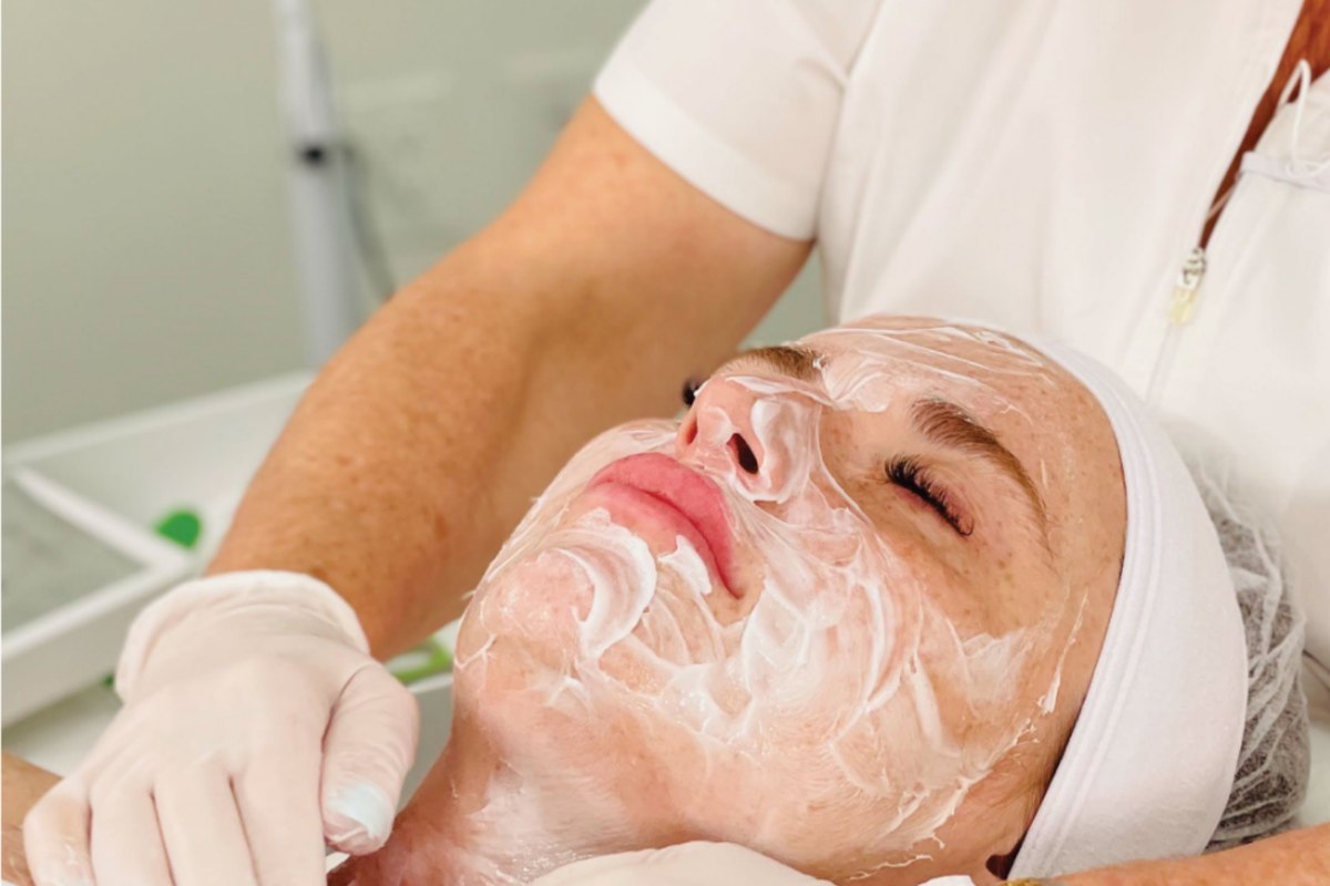 An esthetician applying a seaweed mask during a professional facial